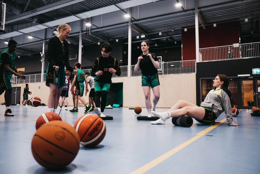 Ungdommer i Skjetten basket trener skadeforebyggende med baller, bånd og balanse